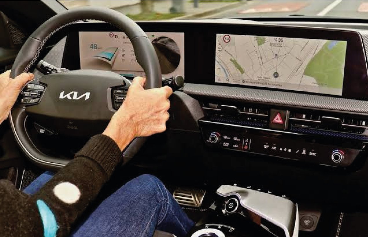 Ecran d'une Kia électrique affichant les kilomètres d'autonomie restants, pare-brise recouvert de givre en arrière plan
